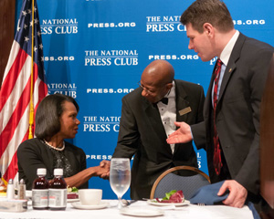 Fans Gwen Ifill and Judy Woodruff, PBS anchors, flank head table waiter Andrew Price on July 24 at the final luncheon of his 45-year career.