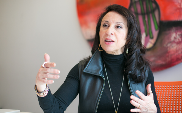 Maria Hinojosa wearing a black jacket and speaking