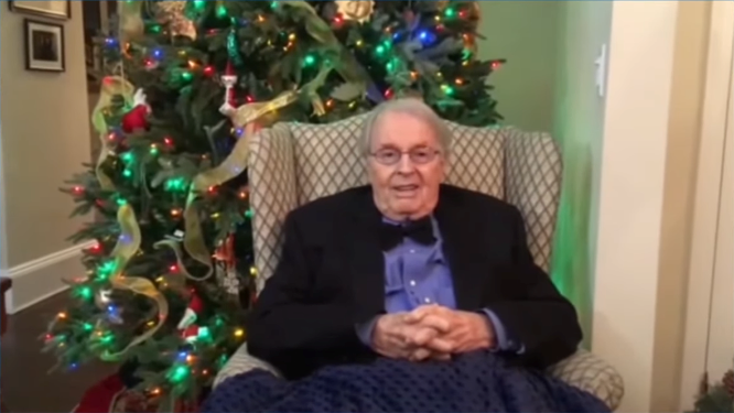 Photo of Charles Osgood in front of his Christmas tree.