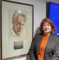 Photo of Noel-Marie Fletcher with portrait of Ernie Pyle